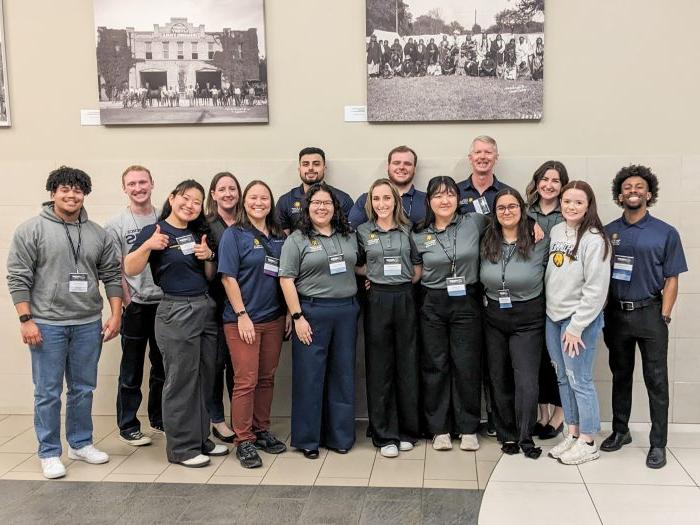 A group of faculty and students pose for a picture.